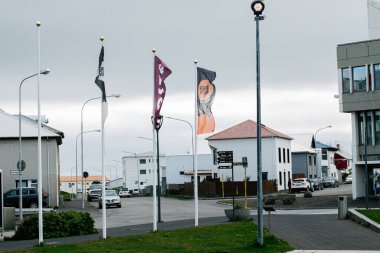 Akranes, İzlanda - 15 Mayıs 2025: Akranes, İzlanda 'da şehir sokak sahnesi, bayraklar ve bulutlu bir atmosfer