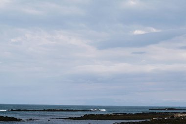 Sakin sularla sakin bir sahil manzarası ve İzlanda, Akranes 'de açık bir gökyüzü..