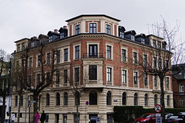 Kopenhag, Danimarka - 21 Nisan 2025: Danimarka 'da çok katlı zarif tuğla ve taş bina, ağaçlarla çevrili mimari.