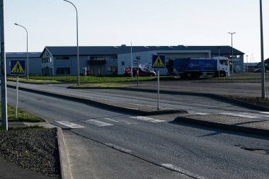 Akranes, İzlanda - 16 Mayıs 2025: Akranes 'te binalarla, yaya geçişleriyle ve park halindeki araçlarla şehir yolu kavşağı