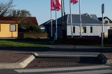 Akranes, İzlanda - 16 Mayıs 2025: Akranes, İzlanda 'da şehir manzarası, evlerin, bayrakların, yeşilliklerin ve elektrikli scooterın yer aldığı