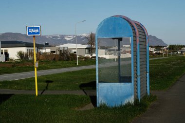 Güneşli bir günde Akranes, İzlanda 'da terk edilmiş mavi otobüs durağı barınağı