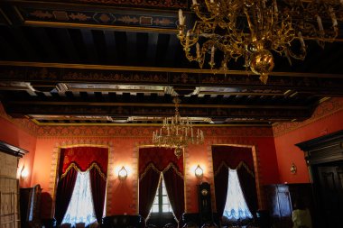 Zbarazh, Ukrayna - 30 Mayıs 2025: Karmaşık detaylar, avizeler ve sıcak renkli duvarlarla süslü tarihi oda.