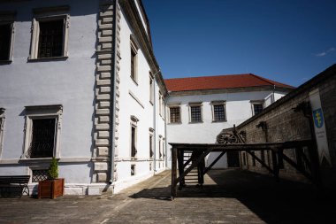 Zbarazh, Ukrayna - 30 Mayıs 2025: Tarihi beyaz binalar, ahşap vagon ve parlak güneşli atmosferi olan bir avlu Zbarazh kalesi.