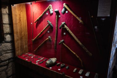 Zbarazh, Ukrayna - 30 Mayıs 2025: Kırmızı zemin ile cam bir kutuda sergilenen antika aletler koleksiyonu.