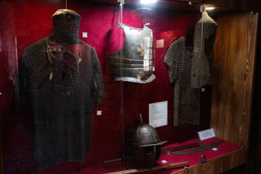 Zbarazh, Ukrayna - 30 Mayıs 2025: Müze vitrininde tarihi zincir, zırh ve kaskların sergilenmesi.