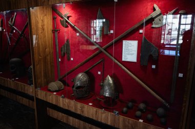 Zbarazh, Ukrayna - 30 Mayıs 2025: Müzenin korumalı cam kaskında sergilenen tarihi silah ve miğferler