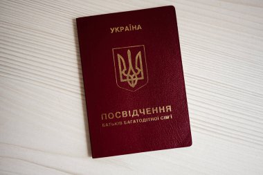 Kyiv, Ukrayna - 30 Mayıs 2025: Ukrayna aile sertifikası kitapçığı, kamera yakınlarındaki ahşap yüzey üzerinde ulusal amblemi gösteriyor