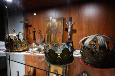 Zbarazh, Ukrayna - 30 Mayıs 2025: Süslü bir sergi dolabında dekoratif taçlar ve dini eşyalar sergilendi