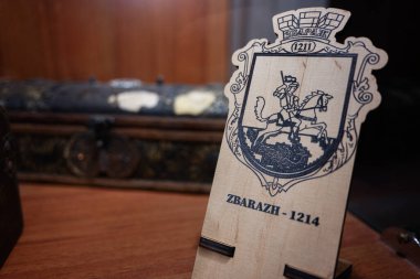 Zbarazh, Ukrayna - 30 Mayıs 2025: Antik arkaplan arkalı bir arma sergilenen oymalı ahşap tabela.