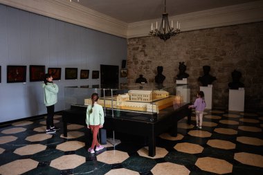 Zbarazh, Ukrayna - 30 Mayıs 2025: Müze ortamında tarihi sanat eserlerini, heykelleri ve mimari modelleri izleyen ziyaretçiler