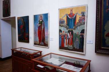 Zbarazh, Ukrayna - 30 Mayıs 2025: Tarihi bir müze sergisinde elle boyanmış duvar resimlerine ve antika eşyalara bakmak