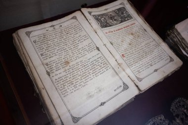 Zbarazh, Ukrayna - 30 Mayıs 2025: Süslü tasarımı ve tarihi metni bir müze ortamında sergilenen antik kitap.