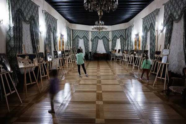 Zbarazh, Ukrayna - 30 Mayıs 2025: Güzelce tasarlanmış klasik temalı bir galeri alanında sanat sergileri keşfeden ziyaretçiler
