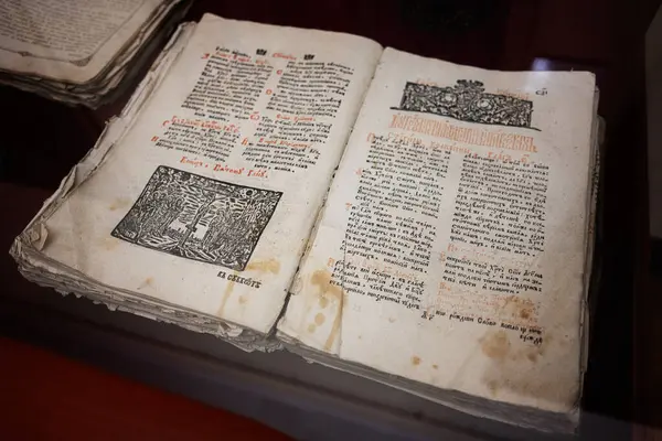 Zbarazh, Ukrayna - 30 Mayıs 2025: Ortaçağ metinleri ve çizimleriyle açılan antik kitap, ahşap bir yüzeyde sergilenmektedir..