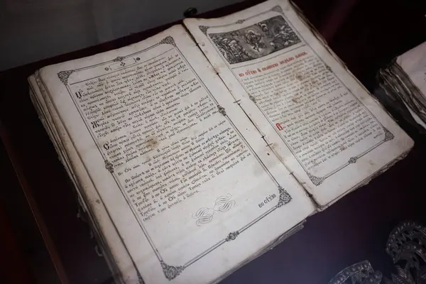 Zbarazh, Ukrayna - 30 Mayıs 2025: Süslü tasarımı ve tarihi metni bir müze ortamında sergilenen antik kitap.