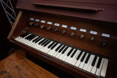 Etiketli ses ayarları ve karmaşık klasik tasarımı olan ahşap antik klavye enstrümanı.