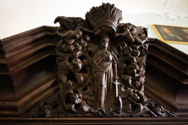 Karmaşık tasarımlarla çevrili bir kılıçla taçlandırılmış bir figürü ayrıntılı şekilde tasvir et.