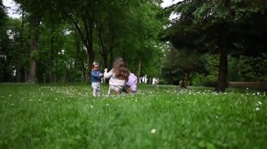 Üç kız kardeş bir yaz günü yeşil bir parkta birlikte oynuyorlar..