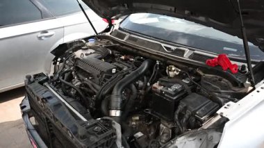 Kaputu açık araba motoru, çeşitli bileşenlerin yakın çekim görüntüsü.