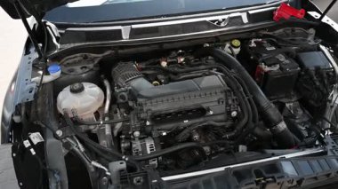 Görünür bileşenleri ve kabloları olan bir araba motorunun yakın plan görüntüsü.