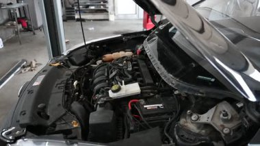 Otomobilin motoru garajda kapanır. Pil, hidrolik direksiyon sıvı deposu, diğer bileşenler..