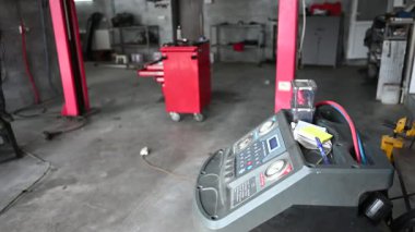 Asansörlü bir araç ve klima kurtarma makinesi olan bir araba tamirhanesi..