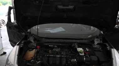 Garajda kaputu açık bir araba motoru..