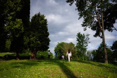 Açık havada, yemyeşil bir tepede yürüyen insanları gösteren rahatlatıcı bir an..