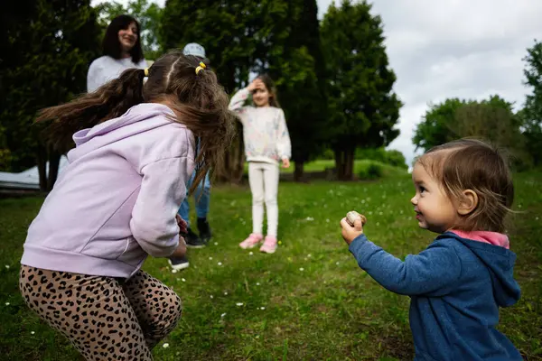 Yeşillik ve temiz havayla çevrili bir grup çocuk dışarıda eğleniyor.