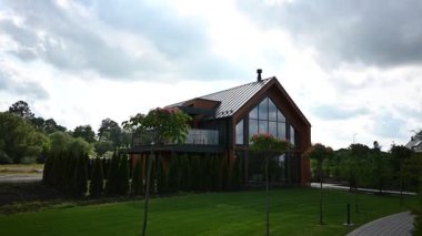 Güzel yeşil doğa ve peyzaj arasında geniş pencereleri olan çarpıcı modern mimari ev..