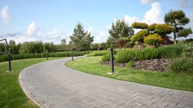 Huzurlu asfalt bir yürüyüş yolu güzel bir peyzaj parkında kıvrılarak huzurlu bir açık hava manzarası sunar..