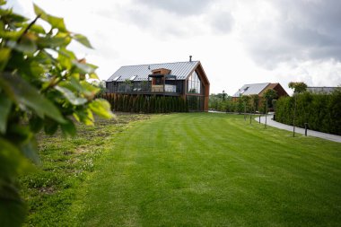 Çağdaş ev, manzaralı çimenlikleri ve ağaçları olan kırsal bir alanda yer alıyor..