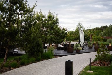 Canlı bitkiler, yürüyüş yolları ve rahat dinlenme alanları olan manzaralı bir alan.