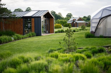 Modern mimari tasarımı olan yeşil bir manzaranın ortasında rahat ahşap bir ev.