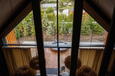 İç dizaynı balkon manzaralı, ahşap teraslı ve dışarıda yemyeşil.