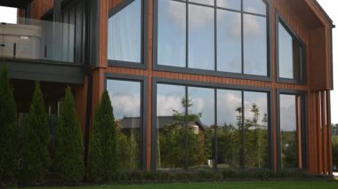 Şatafatlı, çağdaş bir ev etkileyici büyük pencereler ve iyi korunmuş yeşil çimenler..