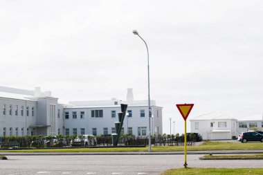 Akranes, İzlanda - 15 Haziran 2025: Modern mimari ve trafik işaretinin yer aldığı bir banliyö caddesi manzarası.