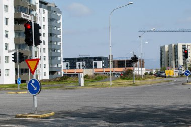 Akranes, İzlanda - 15 Haziran 2025: Kentsel binalar ve yol işaretlerinin yer aldığı bir kavşağın şehir manzarası.