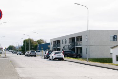 Akranes, İzlanda - 15 Haziran 2025: Akranes, İzlanda 'da arabaları ve binaları olan huzurlu bir banliyö caddesi.