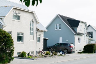 Akranes, İzlanda - 15 Haziran 2025: Akranes 'te huzurlu bir mahalledeki evler, yakınına motosikletler ve modern araçlar park edilmiş..
