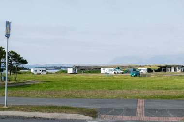İzlanda kıyı şeridi yakınlarındaki çimenli bir arazide park halindeki kervanların Idyllic manzarası.