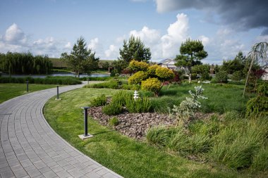Bir patika, bitkiler ve manzaralı bahçe manzarası.