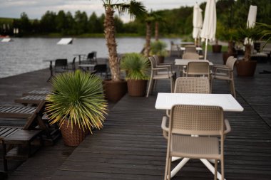 Serin bir gölün yanında, yemyeşil ve palmiye bitkileriyle çevrili, büyüleyici bir açık hava..