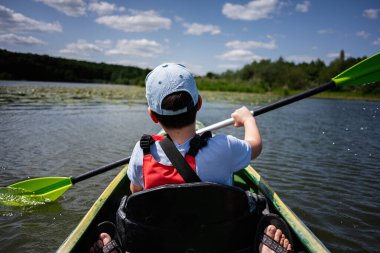Huzurlu bir gölün üzerinde güzel doğal çevresi olan sakin bir kano anı.