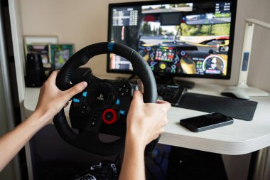 Kyiv, Ukrayna - 17 Haziran 2025: Direksiyon kontrolü ve yarış simülatörü ile aktif oyun kurulumu