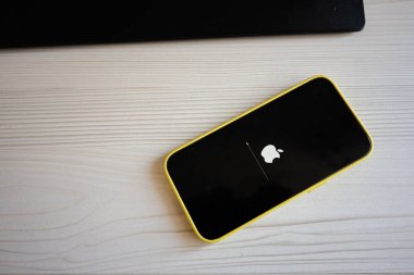 Kyiv, Ukrayna - 17 Haziran 2025: Smartphone Apple Iphone, parlak beyaz bir masa üzerine kurulmuş bir önyükleme ilerleme çubuğunu gösteriyor