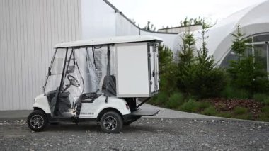 Çeşitli ulaşım ihtiyaçları için arka kargo kutusu olan temiz, beyaz bir elektrikli araç..