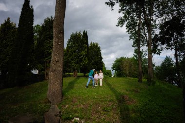 Güneşli bir günde parkta birlikte vakit geçiren bir aile.