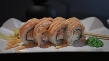 İştah açıcı suşi ruloları taze karides, aromalı sos, zencefil turşusu ve wasabi ile güzelce düzenlenmiş..